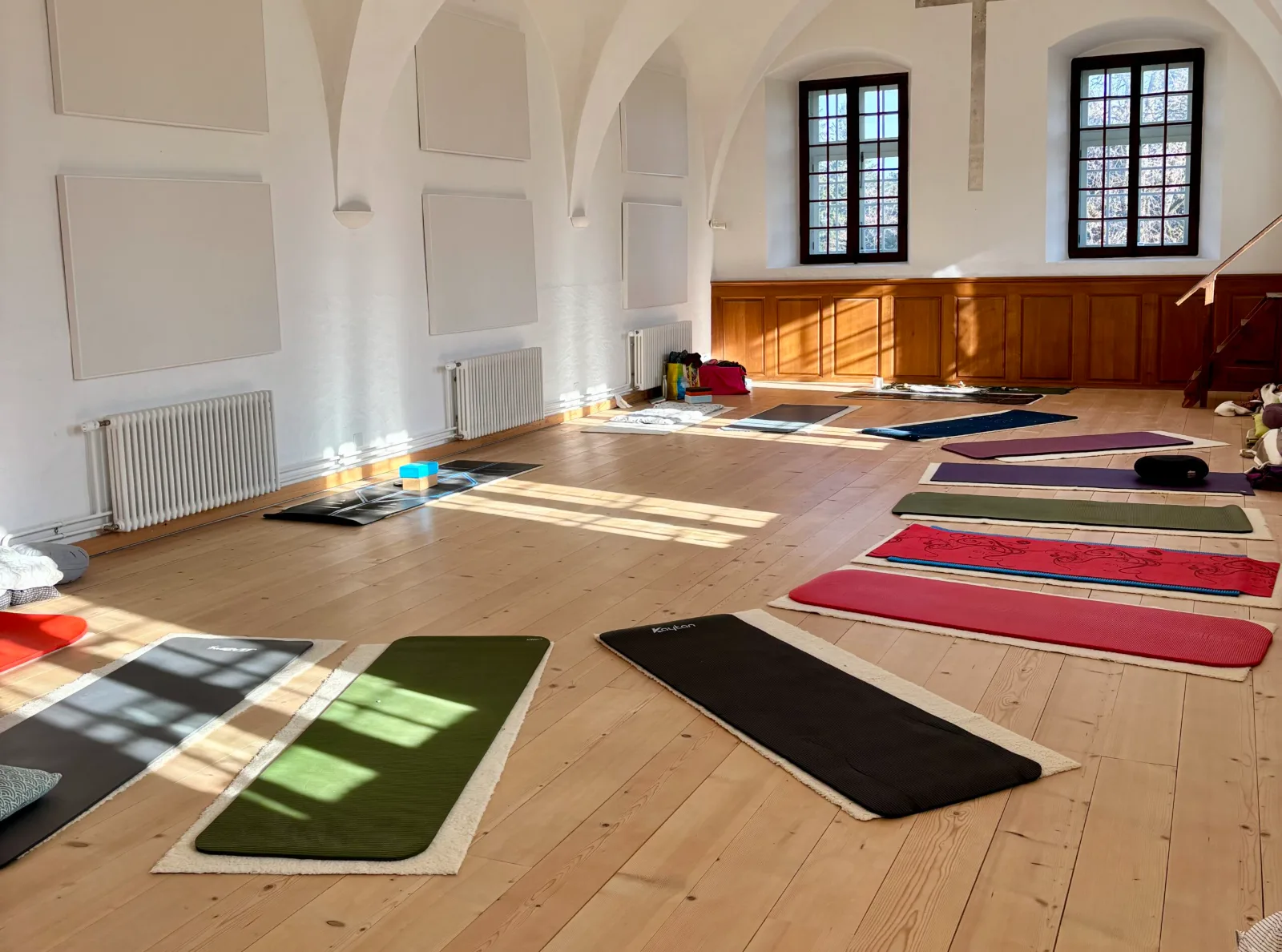 Salle de pratique avec tapis de yoga et lumière naturelle