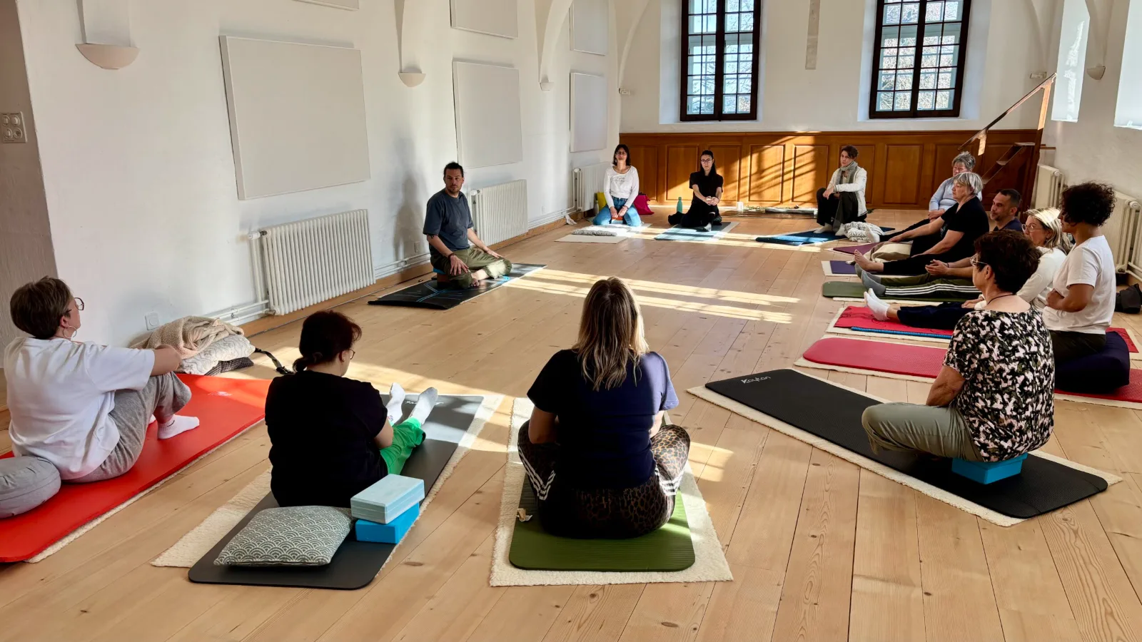 Participants assis sur des tapis de sol pendant une séance de breathwork